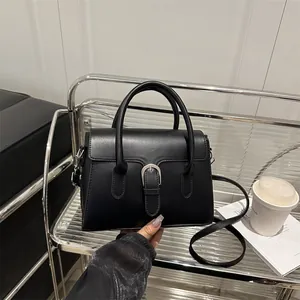 Minimalist black faux leather handbag with silver buckle and detachable shoulder strap