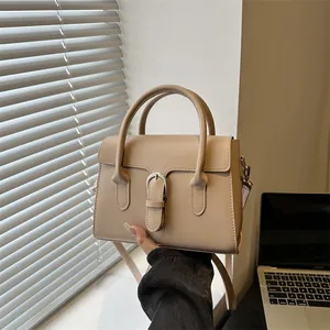 Minimalist beige crossbody handbag with silver buckle and thick handle for daily commute
