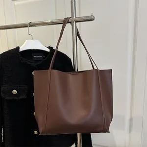Minimalist large brown tote bag with slim shoulder straps for daily commute use