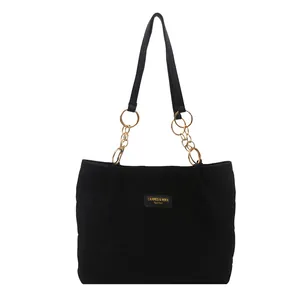 Black quilted tote bag with diamond stitching and gold chain straps for commuting
