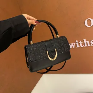 Κομψή μαύρη δερμάτινη τσάντα με γκλίτερ καπάκι και χρυσή αγκράφα πέταλο