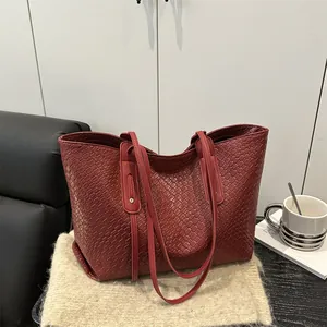 Deep red woven tote bag with premium leather texture and minimalist shoulder straps