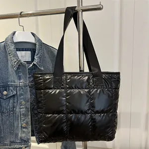 Schwarze gesteppte Puffer-Tasche mit glänzendem Finish und breitem Gurt im Display