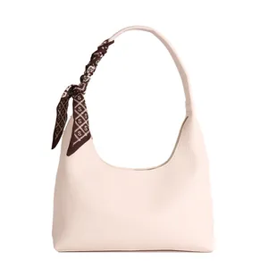 Sac hobo minimaliste rose clair avec un foulard en soie décoratif sur la poignée