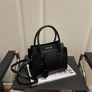 Sac à main chic noir texture serpent avec détails dorés et bandoulière amovible