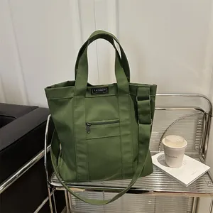 Dark green canvas tote bag with FASHION INSTINCT patch and adjustable shoulder strap