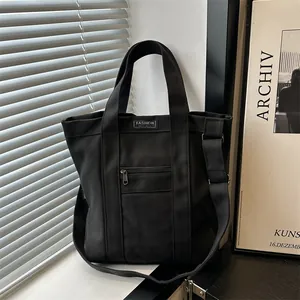 Minimalist black canvas tote bag with adjustable shoulder strap for daily commuting