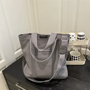 Versatile grey canvas tote bag with adjustable shoulder strap for daily commuting
