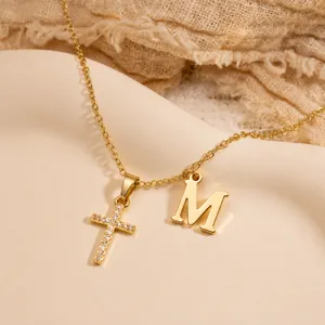 Details der Goldkette mit Zirkonia-Kreuzanhänger und poliertem Buchstaben M