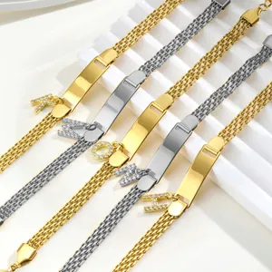 Nahaufnahme von dreilagigen Mesh-Kettenarmbändern mit polierten ID-Platten und Buchstabenanhängern