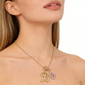 Close-up of gold chain with pavé zircon letter B and pink four-leaf clover pendant