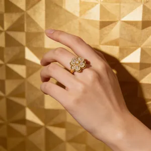 Golden rotating clover ring with cubic zirconia stones worn on a female model finger