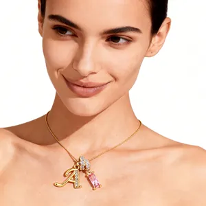 Primer plano de collar dorado con colgante letra A y piedra de circón rosa en una modelo