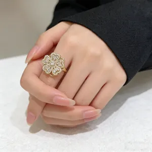 Detailed close-up of a rotating clover ring featuring sparkling zircon stones on a model's hand