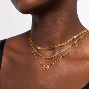 Detail of layered gold necklaces with snake chain, rope chain and toggle OT clasp