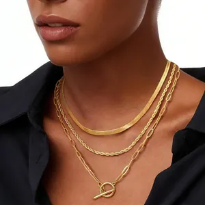 Detailed layered gold necklace with herringbone chain and OT toggle clasp pendant