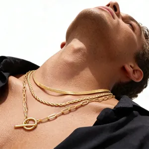 Close-up of golden layered necklaces featuring OT toggle clasp and chunky rope chains