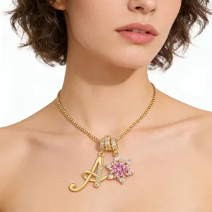 Golden necklace with pink sunflower and crystal letter A pendant on a model's neck