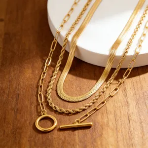 Close-up of gold layered necklaces with OT toggle clasp, rope and snake chain styles