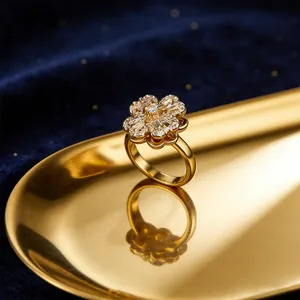 Detail of a rotating clover flower ring with micro-set zircons on a gold tray