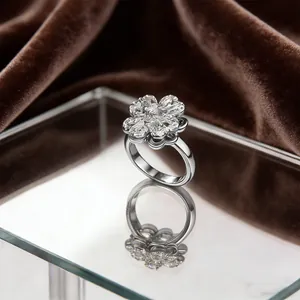 Macro view of rotating clover ring with pavé zircons on a reflective mirror surface