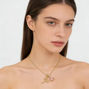 Collar dorado con corazón rosa y colgante letra A de circón en una modelo mujer