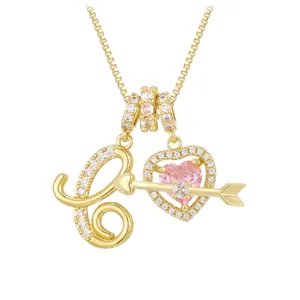Macro shot of gold letter L pendant with pink heart gemstone and sparkling zircons