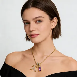 Collana con ciondolo lettera K dorata e zircone viola indossata da una modella