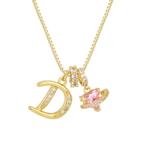 Primer plano del collar dorado con piedra de corazón rosa y colgante letra D con cristales