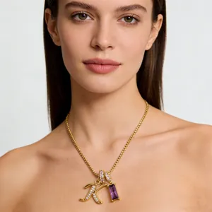 Collana a catena dorata con pendente lettera K in zirconi e gemma rettangolare viola