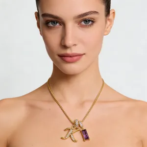 Dettaglio della collana d'oro con ciondolo lettera K e zircone viola su modella