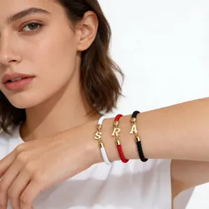 Drei farbige geflochtene Armbänder mit goldenen Buchstabenanhängern S, R und A