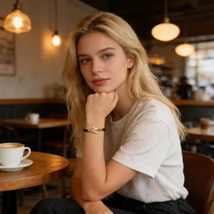 Lifestyle-Foto eines eleganten schwarzen Textilarmbands mit goldenem M-Anhänger