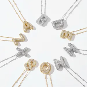Collane con pendenti a forma di lettere in zircone micro-pavé oro e argento su fondo bianco