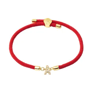 Détail du bracelet cordon rouge avec lettre A sertie de zircons et fermoir ajustable