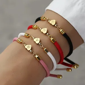 Makroaufnahme verstellbarer geflochtener Armbänder mit Herz-Initialen in vier Farben