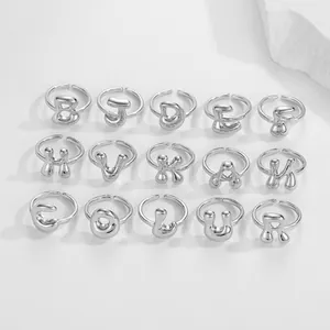 Macro platte weergave van vijftien zilveren verstelbare ringen met gepolijste 3D-alfabetletters
