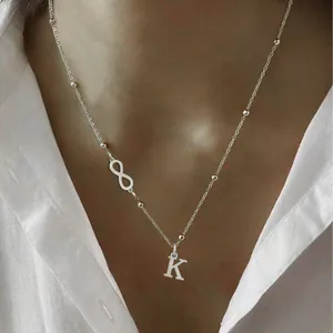 Minimalist silver stainless steel necklace with letter K pendant and infinity symbol detail