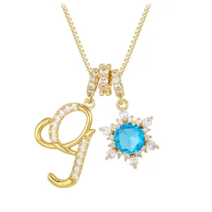 Gold plated box chain necklace featuring letter G and blue stone snowflake pendant