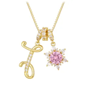 Golden necklace with cubic zirconia letter J and pink snowflake pendant charm