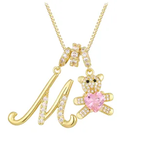 Golden necklace with letter M and bear pendant featuring a pink heart and crystals