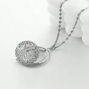 Macro-opname van zilveren holle bolvormige locket met fijn gesneden graveerwerk