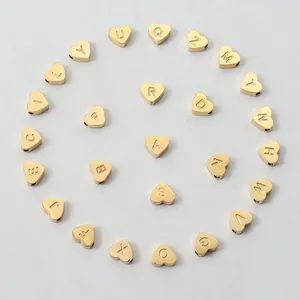 Makroaufnahme von goldfarbenen Herz-Buchstabenperlen für DIY-Schmuck und Armbänder