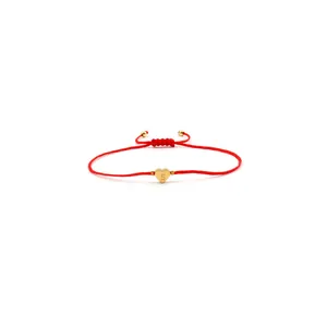 Makroaufnahme von verstellbarem rotem gewebtem Armband mit Herzanhänger und eingraviertem S