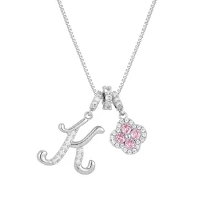Silver necklace with letter K charm and four-leaf clover featuring pink crystals