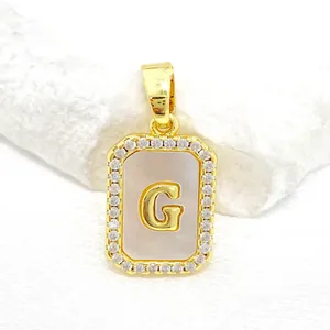 Détail du pendentif carré en nacre avec lettre G et cristaux CZ plaqués or
