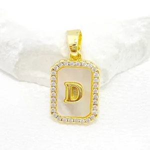 Détail du pendentif en nacre dorée avec lettre D et pavé de cristaux de zircone cubique