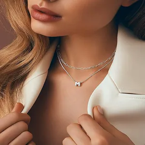 Double-layered silver necklace featuring a paperclip chain and M letter pendant