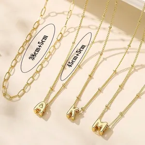 Detailed layered paperclip chain necklace with gold A, K, M letter pendants and size specs