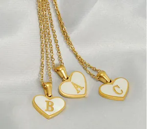 Macro shot of gold heart shell pendants with letters A B and C on fine chain necklaces
